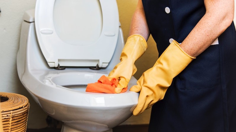 Woman cleaning toilet bowl